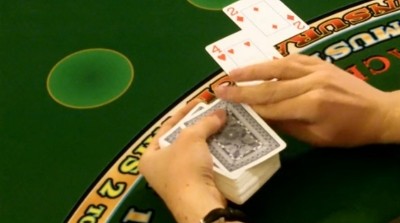 The dealer is hitting the players hand on a handheld deck