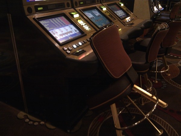 The slot machine has money in it and the chair is tilted forward