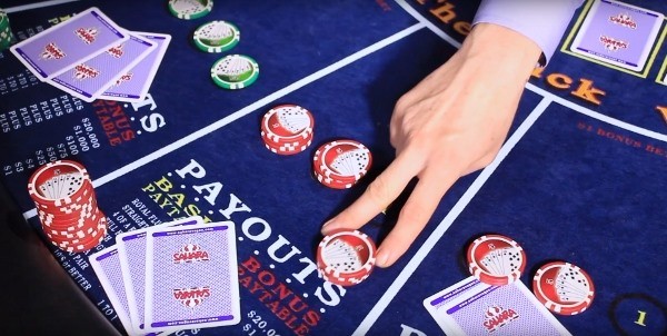 The dealer is pushing the chips back to the player The dealer is pushing the chips back to the player