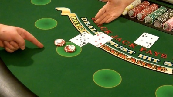 Player is using hand signals for doubling down Player is using hand signals for doubling down
