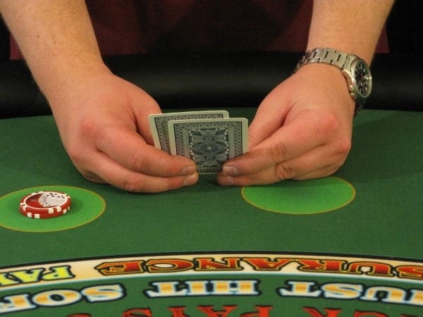 The player is holding the cards with two hands